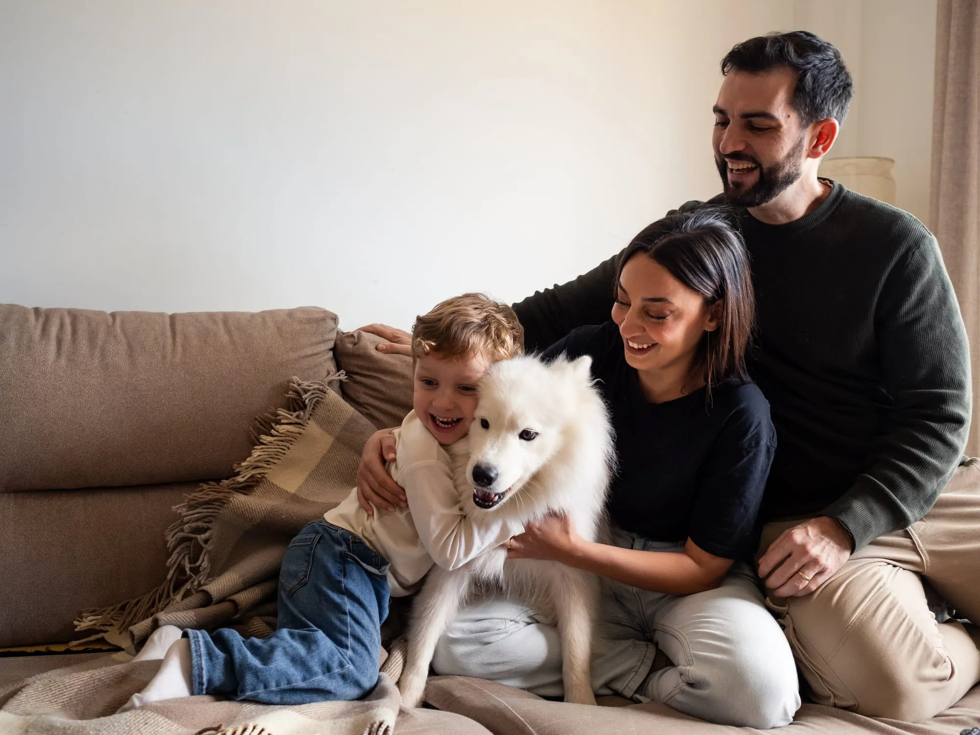Family with young children relaxing with their trained dog